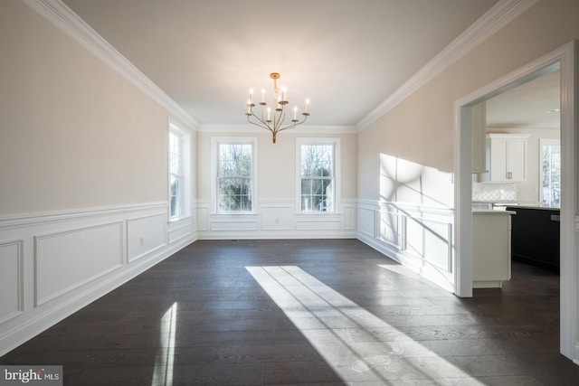 unfurnished dining area with dark hardwood / wood-style flooring, crown molding, and a notable chandelier