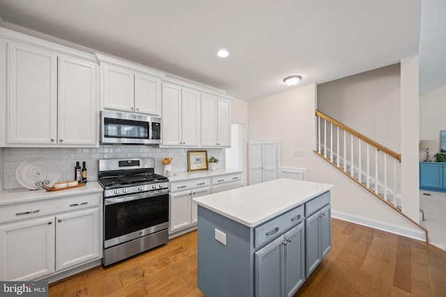 kitchen with white cabinetry, light hardwood / wood-style floors, and stainless steel appliances