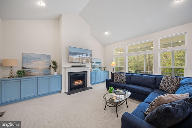 carpeted living room with high vaulted ceiling