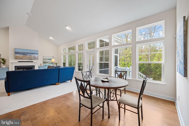 carpeted dining space featuring high vaulted ceiling