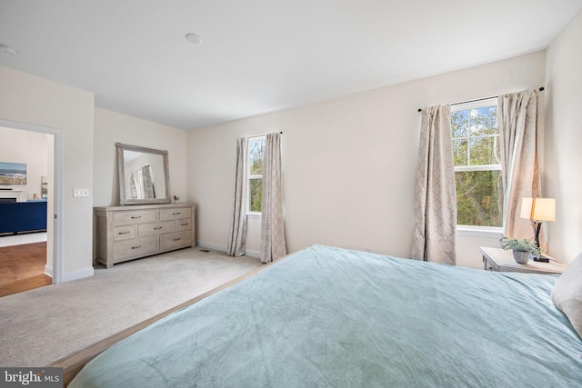 bedroom with light carpet and multiple windows