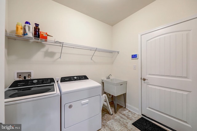 clothes washing area with washer and dryer, hookup for a washing machine, light tile floors, and sink