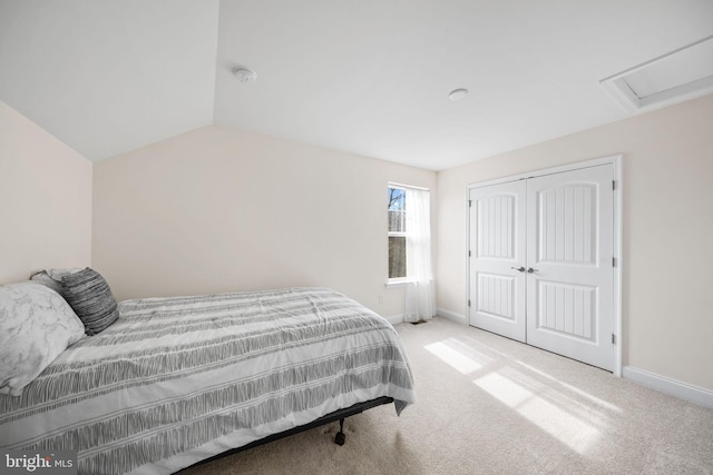 carpeted bedroom with vaulted ceiling and a closet