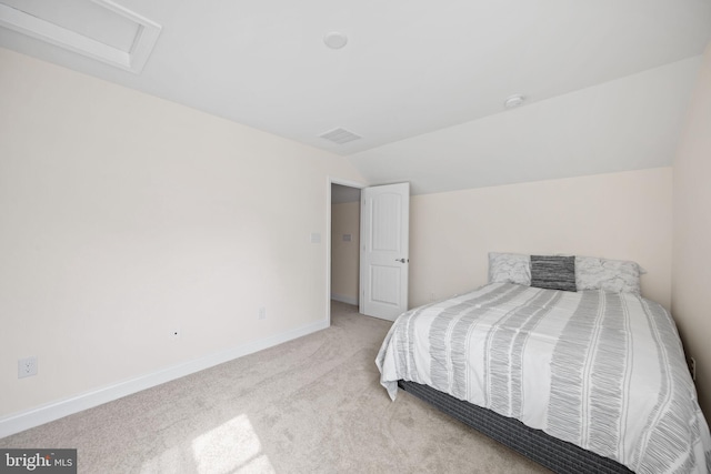 bedroom with lofted ceiling and light colored carpet