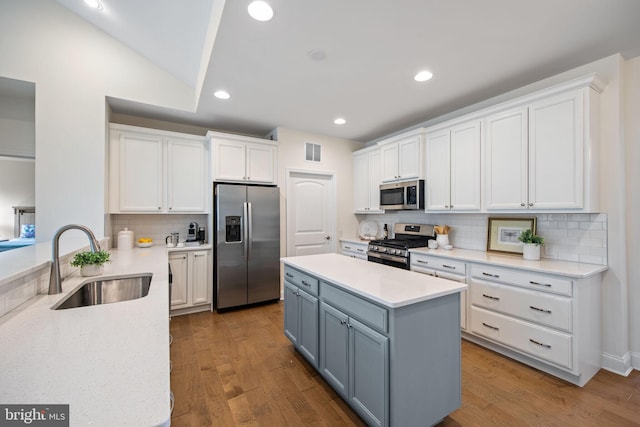 kitchen with appliances with stainless steel finishes, light hardwood / wood-style flooring, tasteful backsplash, and white cabinetry