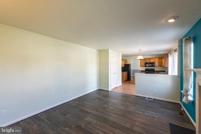 unfurnished living room with sink and dark hardwood / wood-style flooring