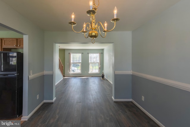 unfurnished dining area featuring dark wood-type flooring and an inviting chandelier