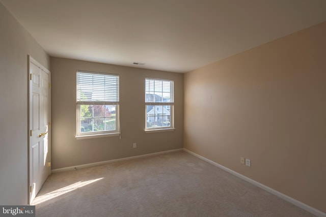 unfurnished room featuring light carpet