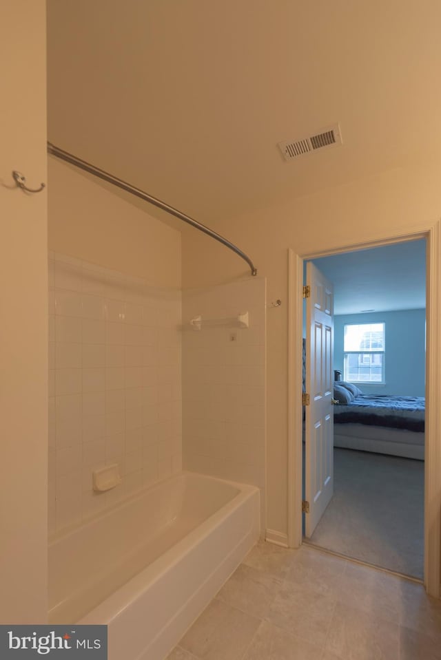 bathroom with tiled shower / bath combo and tile flooring