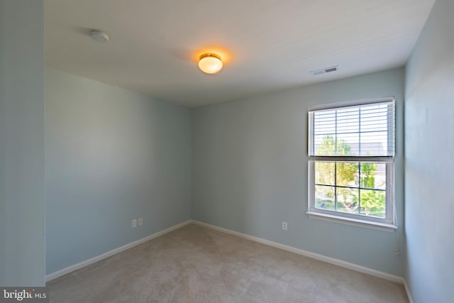 unfurnished room featuring light colored carpet