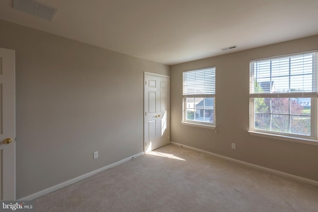 spare room featuring light carpet