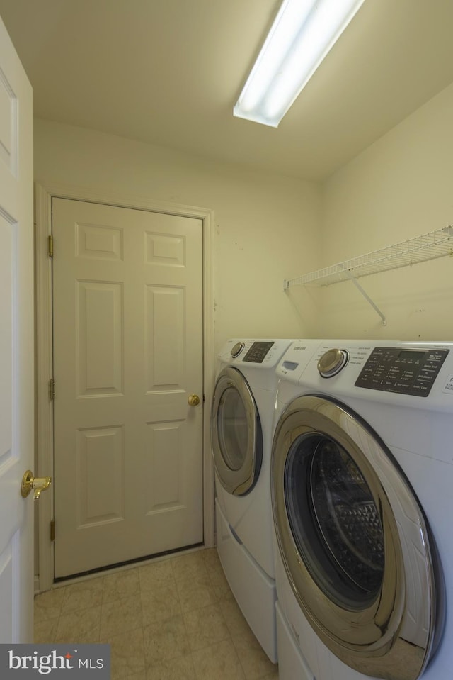 laundry area with washing machine and dryer and light tile floors