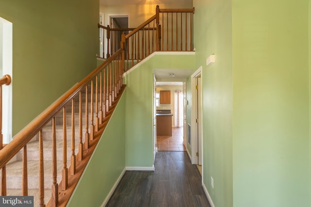 hallway with a high ceiling and dark tile floors