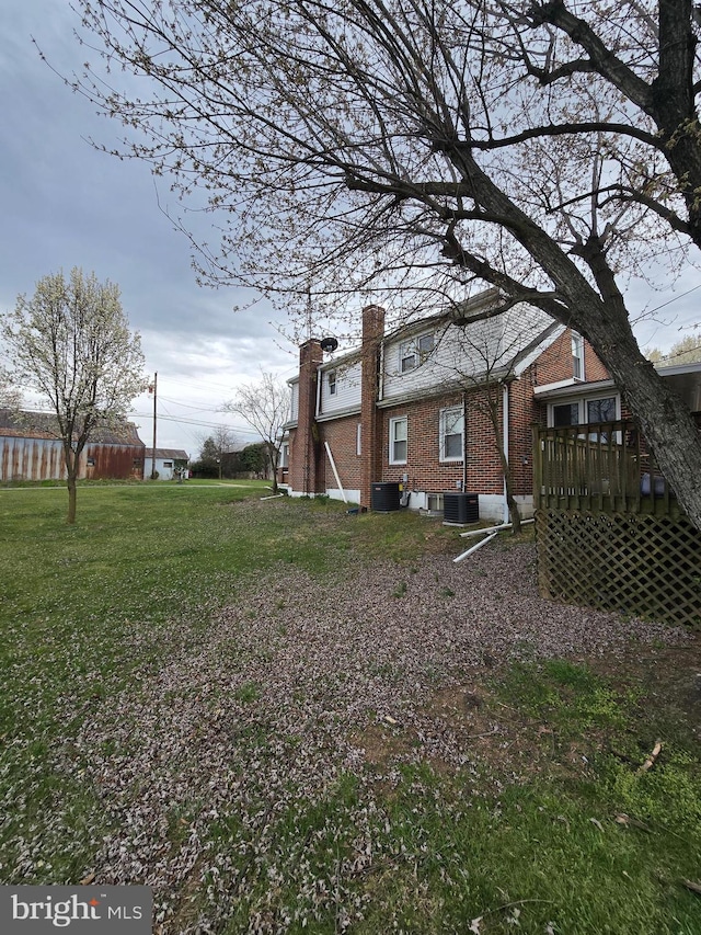 view of yard featuring a wooden deck and central air condition unit