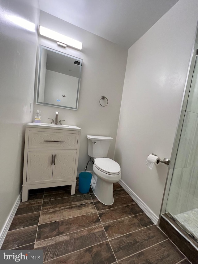 bathroom featuring walk in shower, vanity, toilet, and hardwood / wood-style flooring