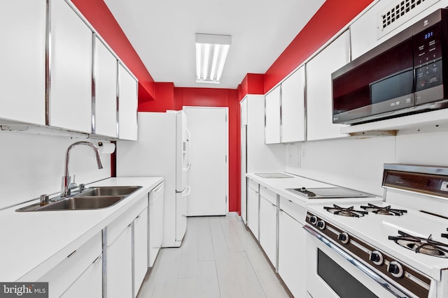 kitchen with white appliances, white cabinets, light tile floors, and sink