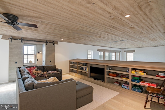 living room featuring a barn door, ceiling fan, wooden ceiling, and light hardwood / wood-style flooring