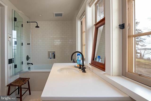 bathroom with vanity and tiled shower / bath