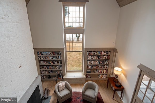 sitting room featuring brick wall and hardwood / wood-style floors