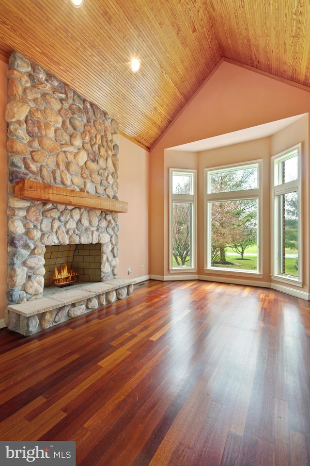 unfurnished living room featuring high vaulted ceiling, wooden ceiling, a stone fireplace, and hardwood / wood-style flooring