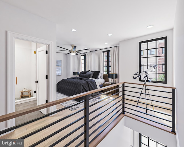 bedroom with hardwood / wood-style flooring and multiple windows