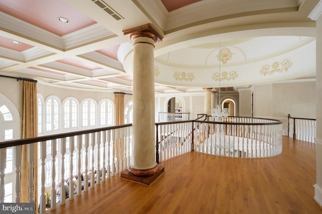 hallway featuring crown molding, coffered ceiling, decorative columns, and wood-type flooring