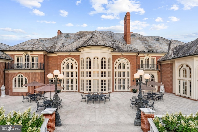 back of house with a balcony, french doors, and a patio area