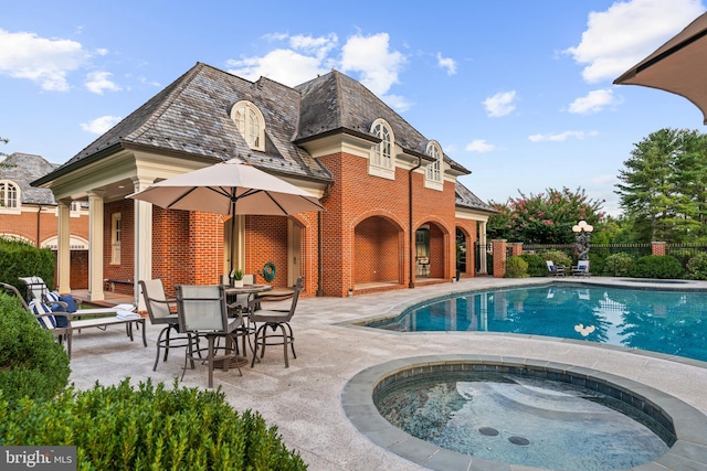 view of swimming pool featuring a patio and an in ground hot tub