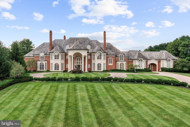 french provincial home with a front lawn