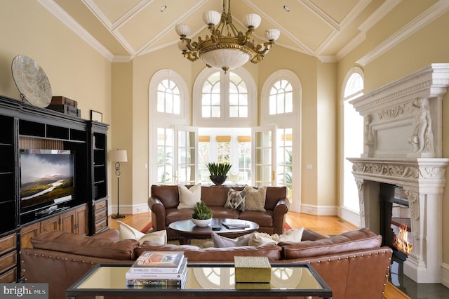 living room with a notable chandelier, high vaulted ceiling, ornamental molding, and hardwood / wood-style flooring