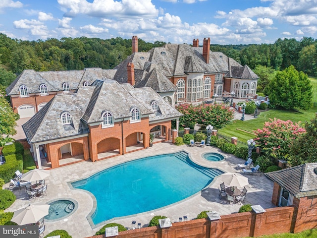 view of pool featuring an in ground hot tub, a yard, and a patio