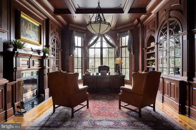 living area with coffered ceiling, light hardwood / wood-style flooring, ornamental molding, and plenty of natural light