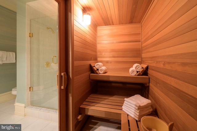 view of sauna / steam room with tile flooring, wood walls, and wooden ceiling