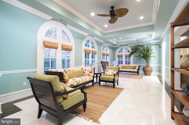 living room featuring a raised ceiling, ornamental molding, ceiling fan, and light tile floors