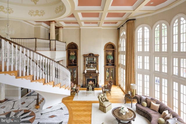 tiled living room featuring coffered ceiling, a healthy amount of sunlight, and ornamental molding