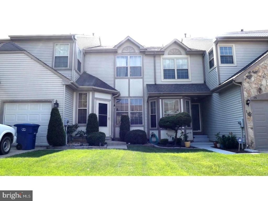 view of front of property with a garage and a front lawn