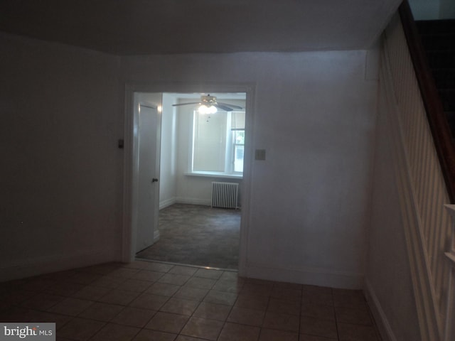 unfurnished room featuring radiator heating unit, tile patterned floors, and ceiling fan