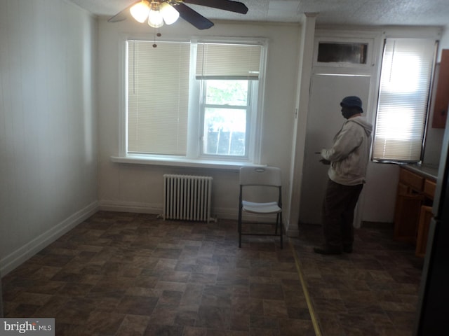 interior space featuring radiator heating unit, plenty of natural light, and ceiling fan