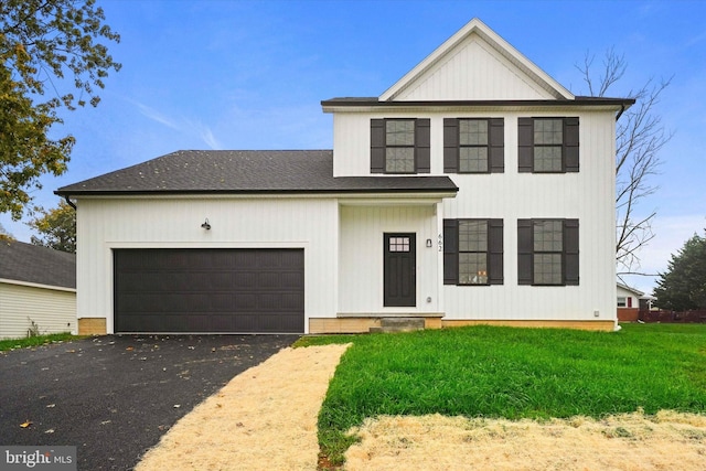 modern farmhouse with a front yard and a garage