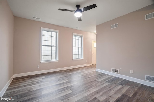 unfurnished room with ceiling fan, dark hardwood / wood-style floors, and a wealth of natural light