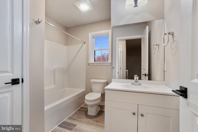 full bathroom featuring toilet, large vanity, hardwood / wood-style floors, and shower / tub combination