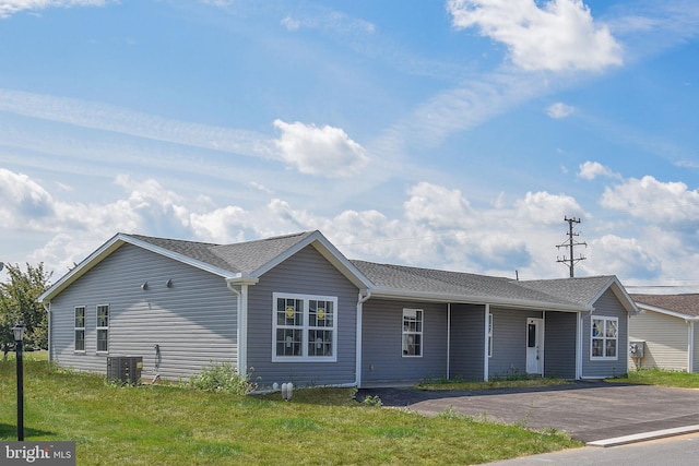 view of front of property with central AC unit and a front lawn