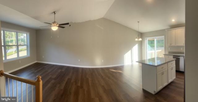 kitchen featuring dishwasher, a center island, white cabinetry, and vaulted ceiling