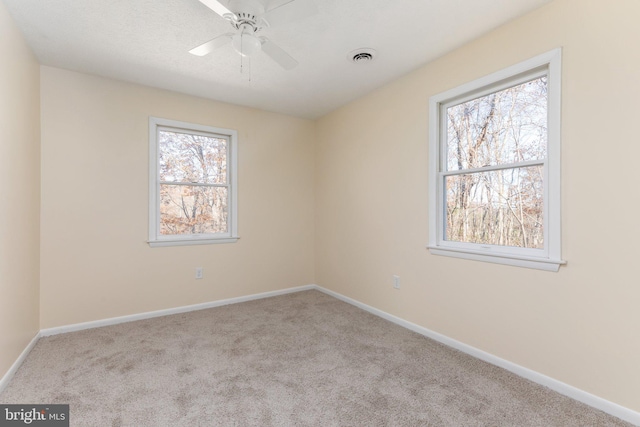 carpeted spare room featuring ceiling fan