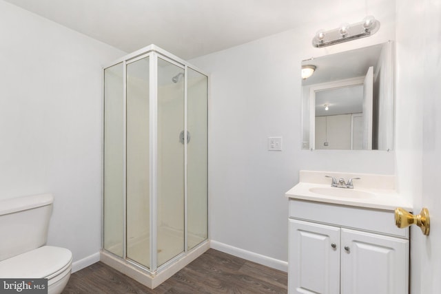 bathroom featuring vanity, toilet, hardwood / wood-style flooring, and an enclosed shower