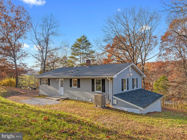 view of front of property featuring a front yard and central AC