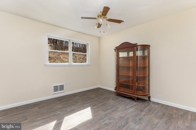 spare room featuring dark hardwood / wood-style floors and ceiling fan