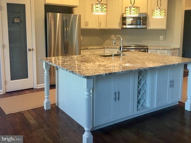 kitchen featuring light stone countertops, pendant lighting, dark wood-type flooring, and white cabinets