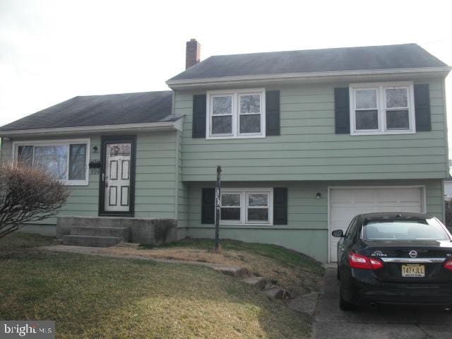 split level home featuring a front lawn and a garage