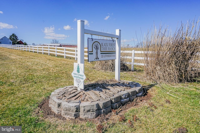 community sign featuring a rural view and a yard